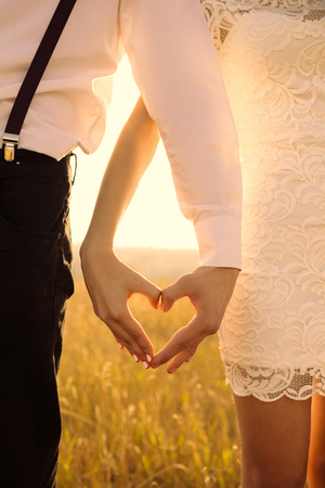 Young couple in love. Hands in shape of love heartの写真素材