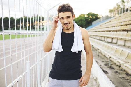 Jogger resting after running. Man runner taking a break during training outdoors. Young Caucasian male fitness model after work out.の写真素材
