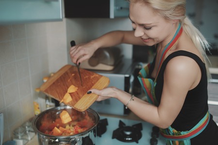 Young woman preparing pumpkin soup in her kitchenの写真素材