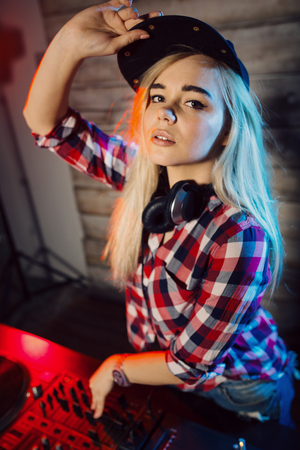 Cute dj woman having fun playing music on vinyl record deck at club party nightlife lifestyleの写真素材