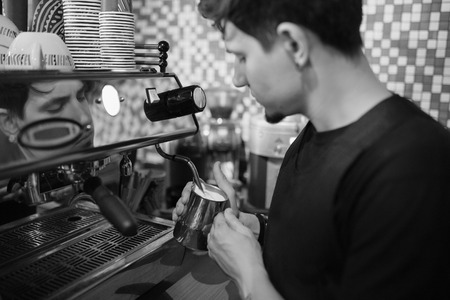 Barista at work in a coffee shop. Preparation service concept. Black and white photoの写真素材