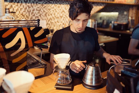 Barista at work in a coffee shop. Preparation service conceptの写真素材
