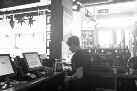 Barista at work in a coffee shop. Preparation service concept. Black and white photoの写真素材
