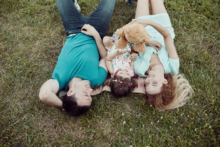 Beautiful happy family spending time together outside in green nature.の写真素材