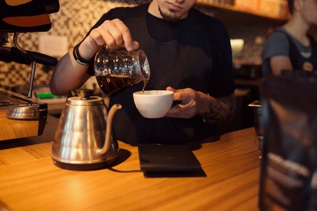 Barista at work in a coffee shop. Preparation service conceptの写真素材