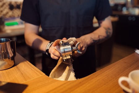 Barista at work in a coffee shop. Preparation service concept. Hands close upの写真素材