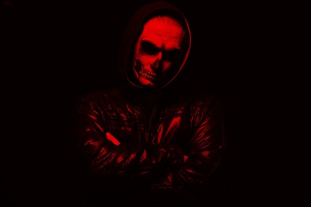 Portrait man with Halloween skull makeup. Halloween or horror theme. Red filterの写真素材