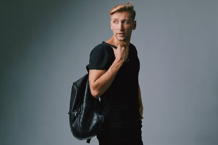 Portrait of a handsome young man smiling against gray background wearing casual clothesの写真素材