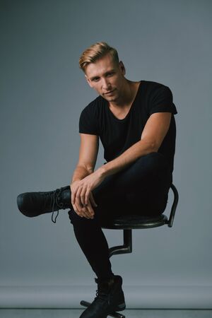 Portrait of a handsome young man smiling against gray background wearing casual clothesの写真素材