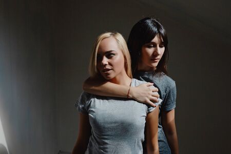 Portrait of two pretty woman posing in dark roomの写真素材