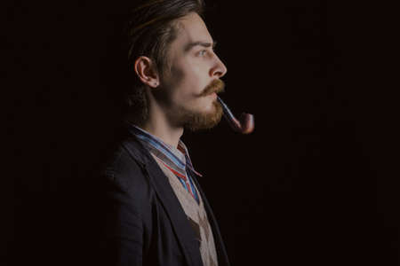 Studio portrait of a serious young businessman wearing a black suit on black background, copy spaceの写真素材