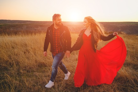 Young couple embracing and kissing outdoor at sunsetの写真素材