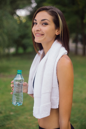 Smiling jogger woman by the lake at sunsetの写真素材