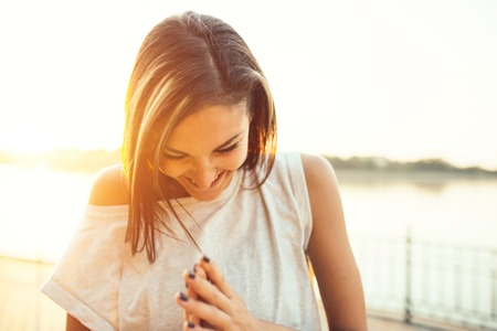 Smiling jogger woman by the lake at sunset. Sport and lifestyle conceptの写真素材