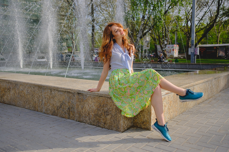 Beautiful brunette young woman wearing skirts and walking on the street in the cityの写真素材