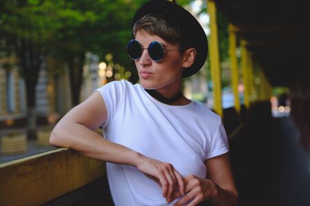 Close up portrait of female hipster with natural makeup and short haircut enjoying leisure time outdoorsの写真素材