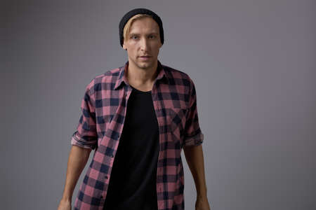 Portrait of a handsome young man smiling against gray background wearing casual clothesの写真素材