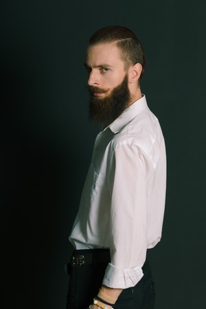 Hipster style bearded man white shirt in studio over black backgroundの写真素材