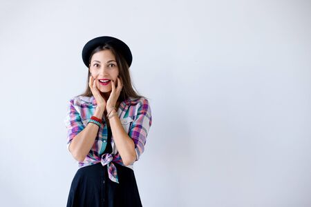 Surprised young woman touching her cheeksの写真素材