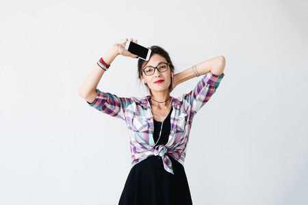 Girl dancing and showing the phoneの写真素材