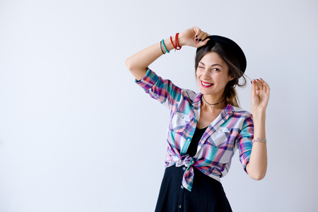 Hipster girl smiling wide and winking in studioの写真素材