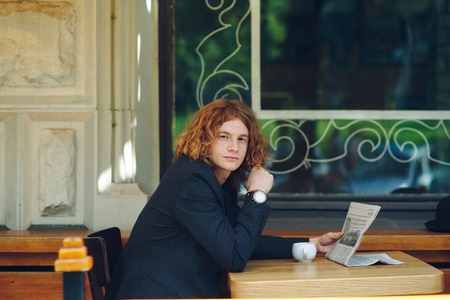 Hipster man drinking coffee while reading