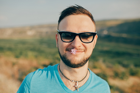 Young man smiling and enjoying sunny summer dayの写真素材