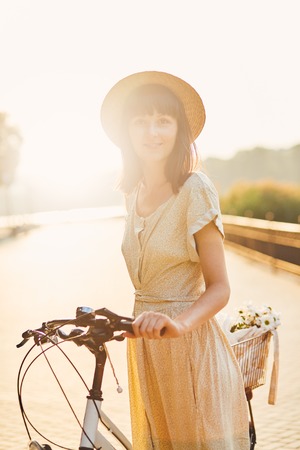 Young woman against nature background with bikeの写真素材