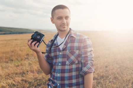 Attractive male photographer outdoors at sunsetの写真素材