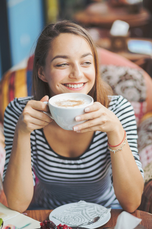 Young woman sitting indoor in urban cafeの写真素材
