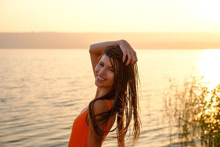 Attractive girl in swimsuit on the beach at sunriseの写真素材