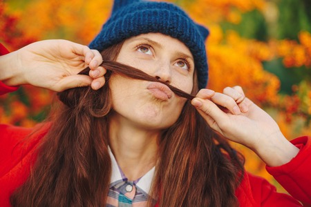 Beautiful girl showing mustache from her hairの写真素材