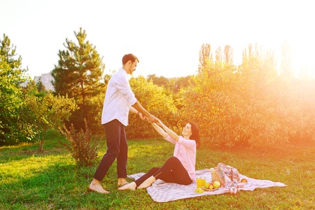 Happy pregnant couple in park on picnikの写真素材