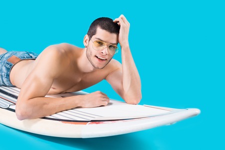 Attractive surfer lying on the board