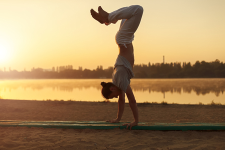 Athletic capoeira performer workout training on the beach sunrisの写真素材
