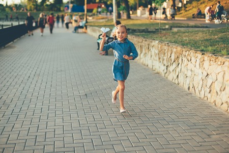 Smiling girl  running with toy paper airplaneの写真素材