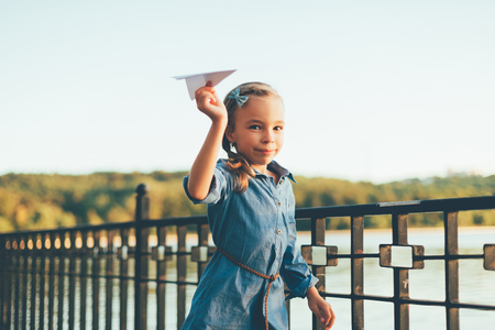 Girl playing, running with toy paper airplaneの写真素材