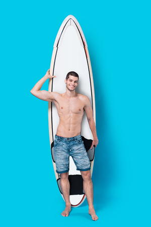 Attractive surfer holding a surfboardの写真素材