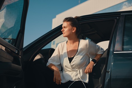 Confident woman getting down from car