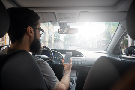 Man using mobile phone while driving.の写真素材