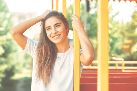 Portrait young, charming student girl relaxing on a sunny day while sitting and dreaming of vacation, futureの写真素材