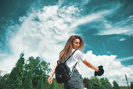 Freedom young woman carefree and happy with open arms on blue sky with hypnotizing sky in...