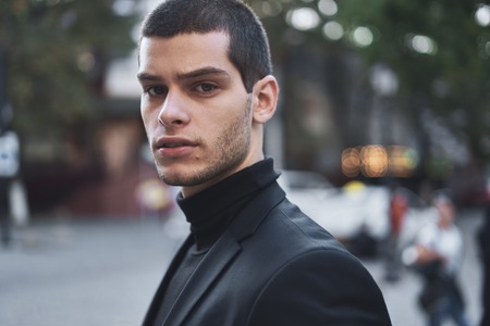 Young man walking, smart casual on an autumn day on a street of European City. Lifestyle Photographyの写真素材