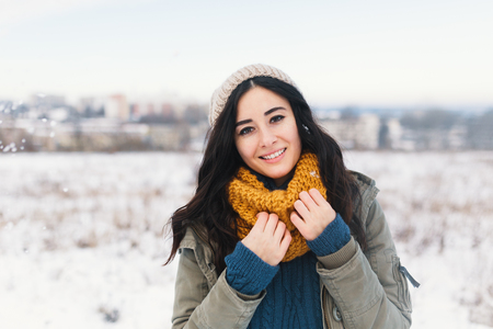 Heart melting winter portrait of pretty young woman enjoying winter, vacation, snow, holiday and her comfy, beautiful clothes and a warm woollen sweater, snood and beanie. Winter dreamy girl.の写真素材