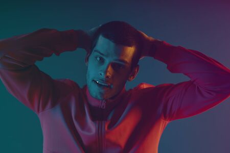 Close-up portrait of attractive male model. Retro wave portrait of a young man at studio. High...
