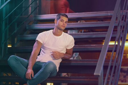 Close-up portrait of attractive male model. Retro wave portrait of a young man in a bar. Model in...
