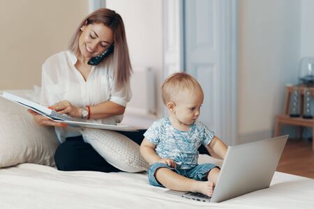 Business mom talking on a cell phone. Multi-tasking, freelance and motherhood conceptの写真素材