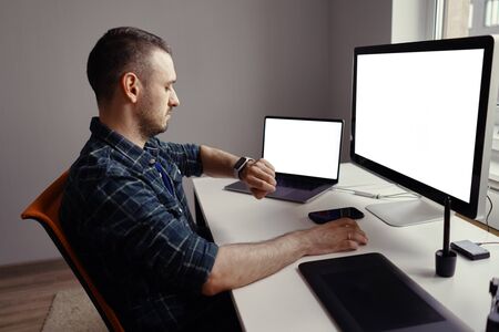 Young man working on his laptop with blank copy space screen for your advertising text message at...