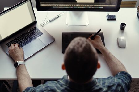 Graphic Designer working with interactive pen display, digital Drawing tablet and Pen on a computer with blank monitor while watching smart watch.の写真素材