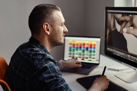 Handsome freelancer man working remotely from home. Young male working on his computer